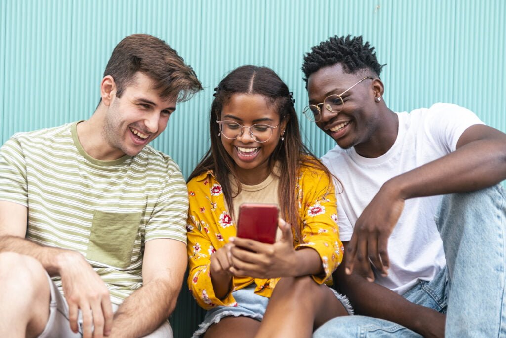 three happy young friends looking mobile phone and 2023 02 02 01 18 10 utc